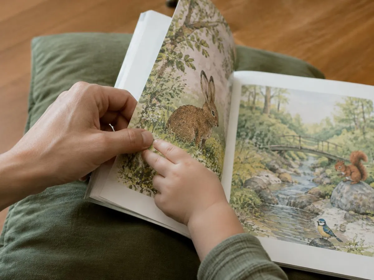 Illustrative photo: a parent's and a child's hands turning the page of a picture book